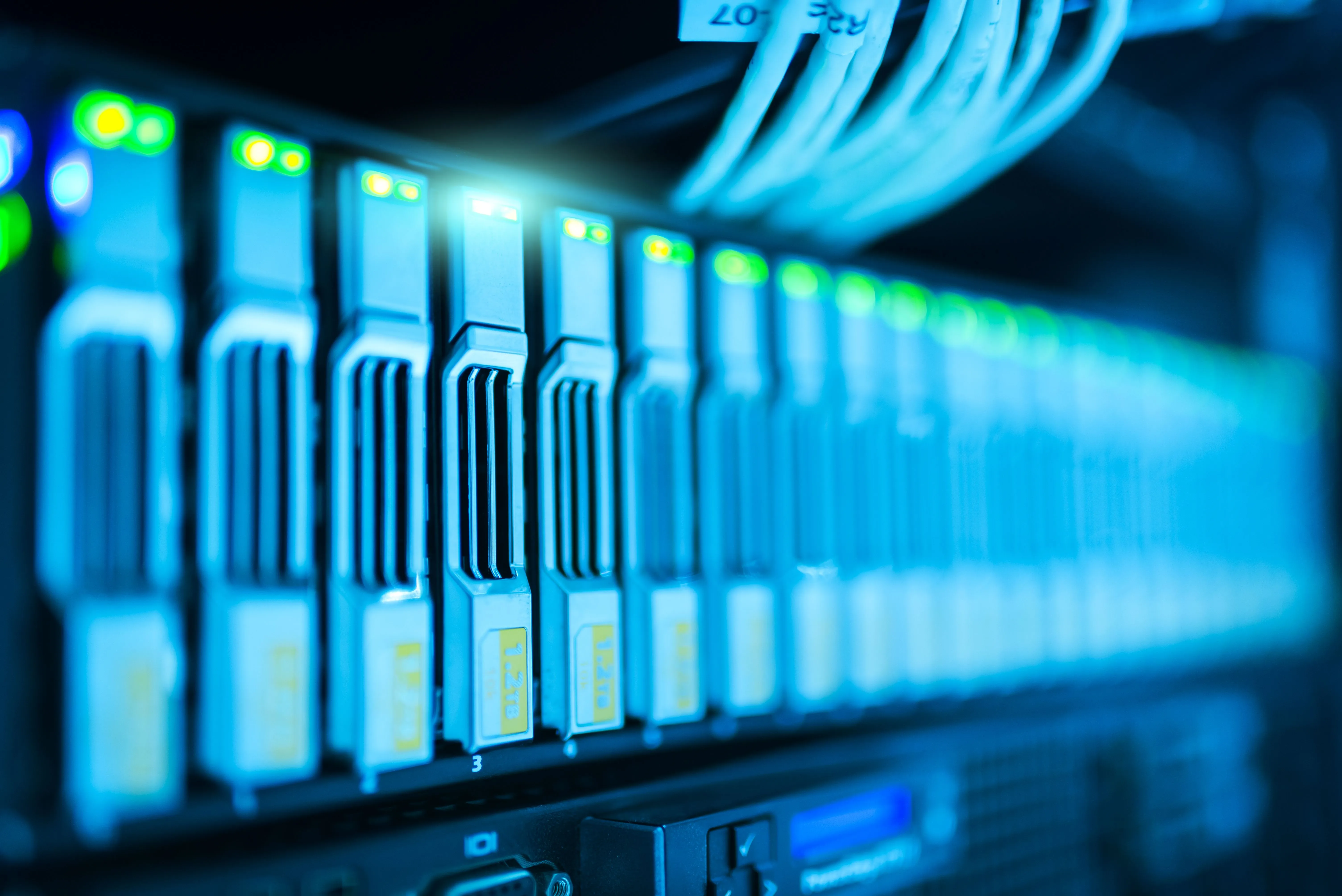 Gros plan sur une rangée de disques durs dans un serveur, voyants verts allumés